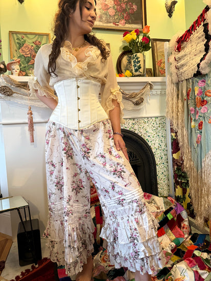 Woman wearing a floral outfit with an ivory satin cincher corset