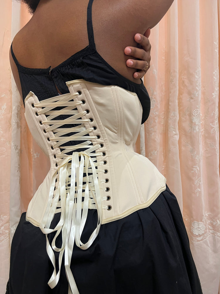 Person wearing a black slip and Myrtle Girdle Corset Petite in Beige on a neutral background